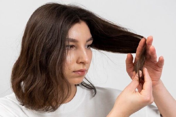 Donna misurando la lunghezza dei propri capelli.