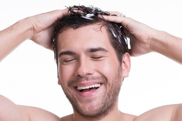L'uomo ride mentre si lava i capelli