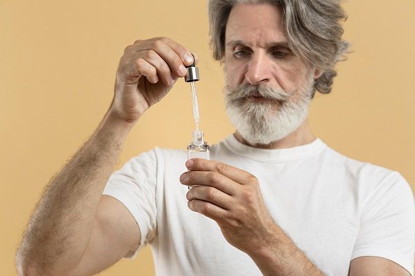 uomo barbuto che usa un contagocce