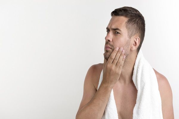 uomo pensieroso con un asciugamano sulla spalla