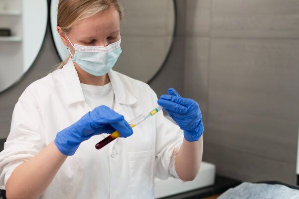 ripresa media di un addetto al laboratorio con una provetta - trapianto capelli Italia