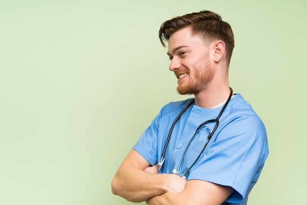 Chirurgo per un trapianto di capelli per uomo in piedi che guarda di lato