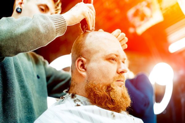 L'uomo dal barbiere si rade i capelli.