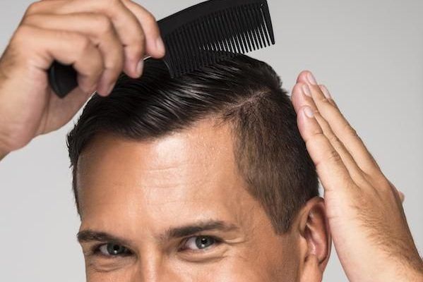 Primo piano della testa di un uomo che si pettina i capelli