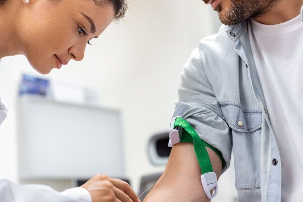 Infermiera che preleva il sangue da un paziente per eseguire alcuni studi.