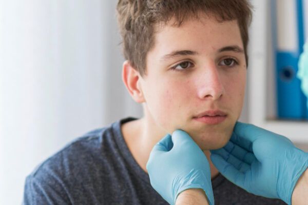 Ragazzo che riceve un controllo da un medico con guanti chirurgici.
