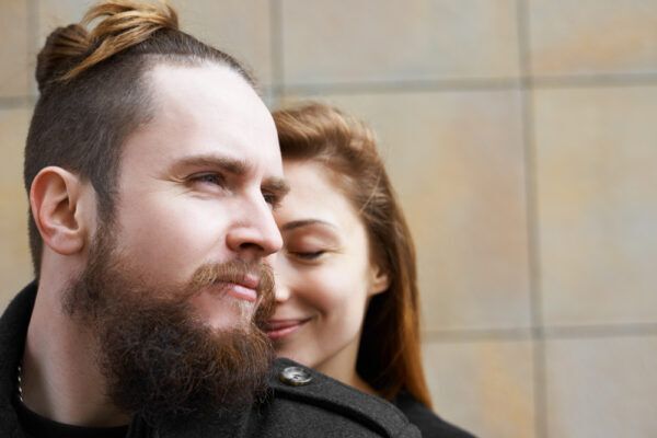 Uomo con capelli lunghi e giacca di pelle in posa con una donna.