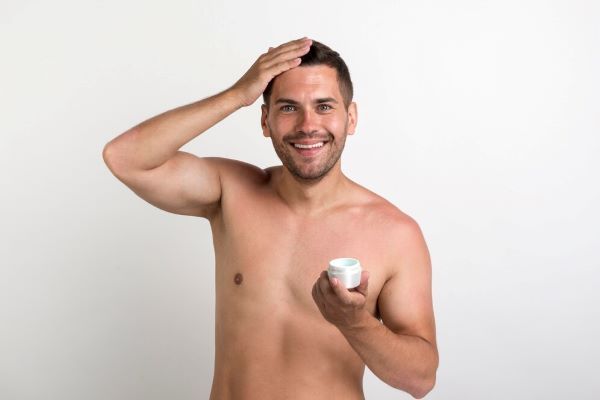 Uomo felice che usa prodotti per capelli