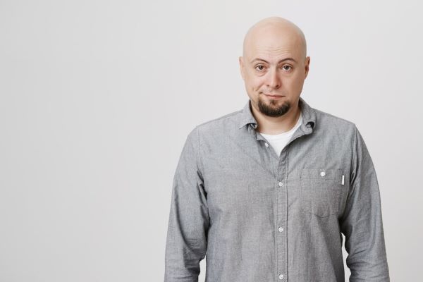 L'uomo calvo guarda la telecamera