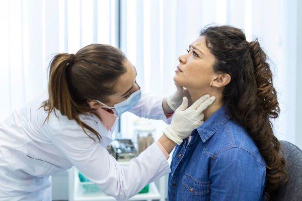Dottore che controlla la gola di una ragazza