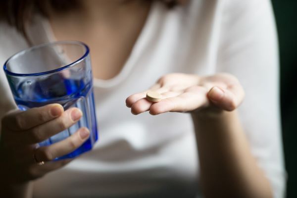 Donna che sta per prendere una pillola