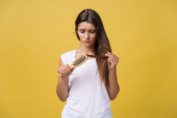 Ragazza preoccupata che si pettina i capelli
