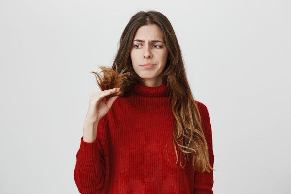 Ragazza che vede le estremità dei capelli delusa