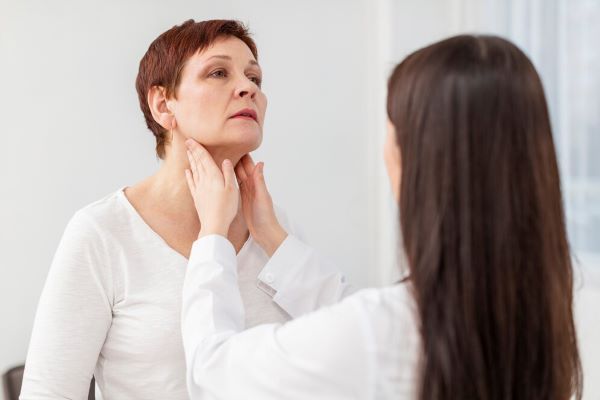 Donna che riceve un controllo della tiroide. Esiste una relazione tra la tiroide e la caduta dei capelli.