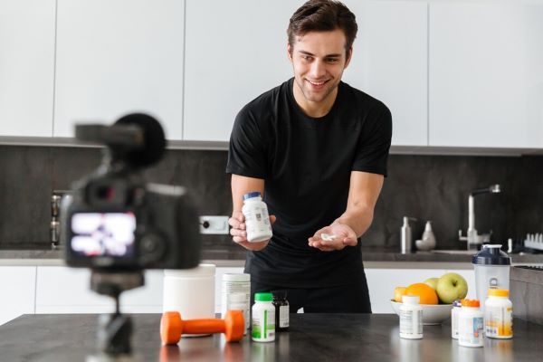 Ragazzo che mostra diversi tipi di vitamine