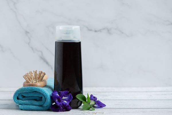 Bottiglia di shampoo fiore su legno