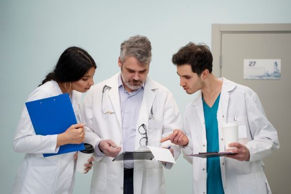 Medici che discutono con le cartelle in mano