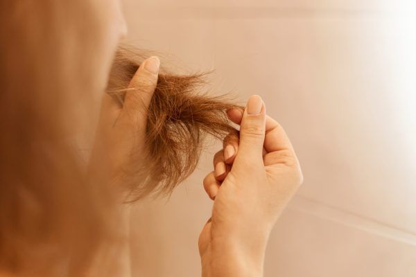 donna osservando i propri capelli - trapianto capelli Italia