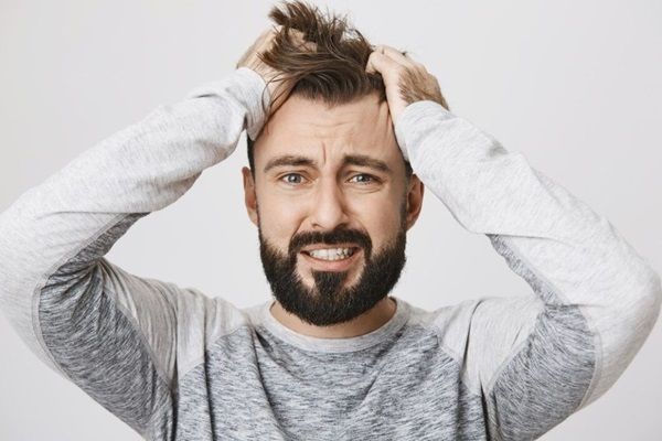 uomo che si tocca la testa disperato alopecia