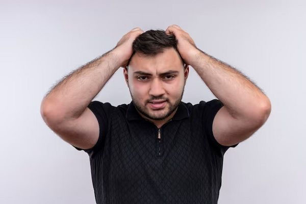 uomo che si afferra i capelli preoccupato