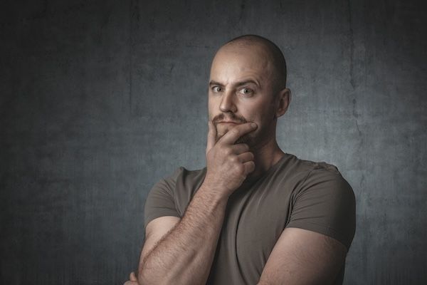 ritratto di un uomo pensieroso con un muro grigio