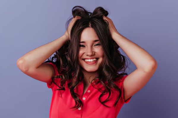 meravigliosa giovane donna con un viso felice che sorride e ride, ragazza spettacolare con un vestito rosso