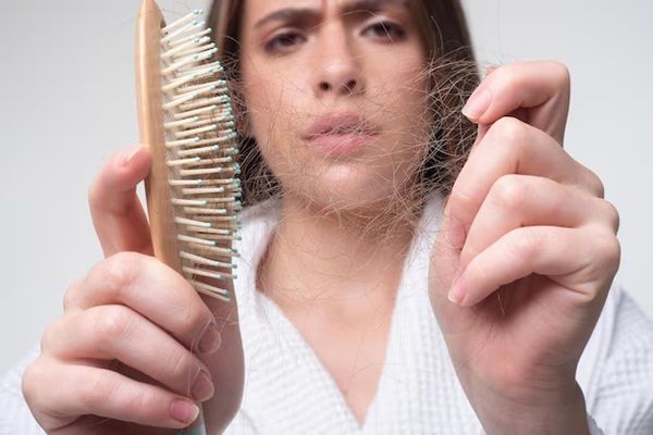 Ragazza triste con capelli danneggiati Trattamento per la perdita dei capelli Ritratto di donna con pettine e problemi di capelli