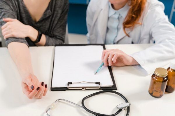 vista di una scrivania con una cartella insieme alle mani di una donna