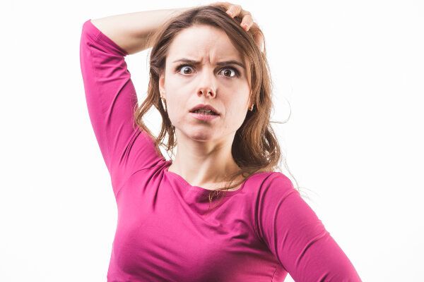 donna bianca che si tocca i capelli con aria preoccupata. Perché cadono i capelli