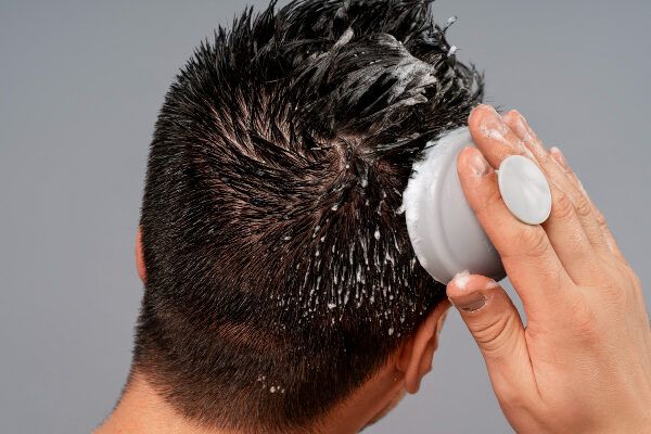 uomo sulla schiena che si lava i capelli