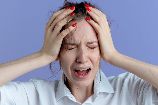 donna bianca che si tocca i capelli con aria preoccupata