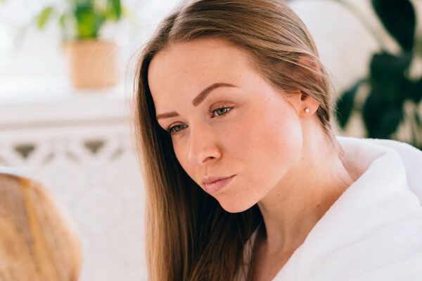 Donna che si guarda allo specchio con uno specchietto - Cosa sono gli scrub? 