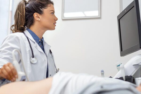 Giovane medico che osserva immagini reali dello stato interno dello stomaco con l'aiuto dei suoi speciali strumenti ad ultrasuoni - Tricofagia: Tutto quello che devi sapere.