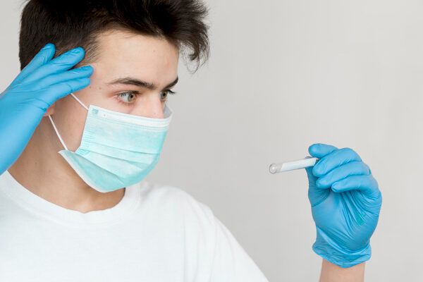 Giovane con maschera, guanti in lattice sulle mani e vaccino.