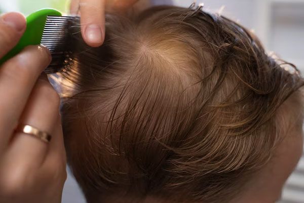 Madre che pettina i capelli di un bambino