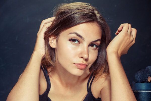 Donna dagli occhi castani che guarda la telecamera con un'espressione seducente.