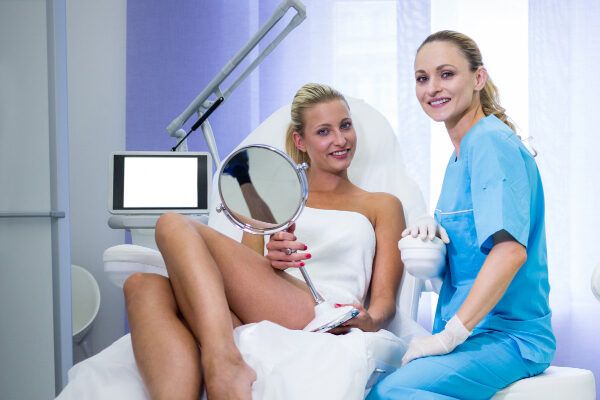 Donna bionda in un ufficio con un medico specialista prima di sottoporsi a un trattamento di bellezza - Laser per capelli.