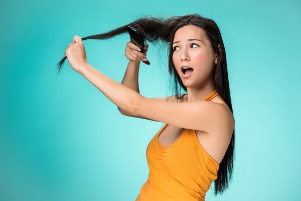 Una donna preoccupata si spazzola i capelli