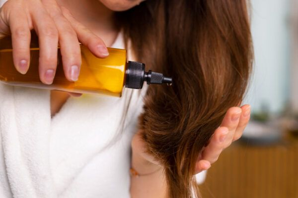 Applica l'olio sulle punte dei capelli con un contenitore contagocce quando esci dalla doccia.