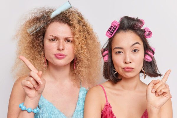 Ragazze di diversi tipi asciugano i capelli con accessori per capelli che si preparano mentre posano per la fotocamera.
