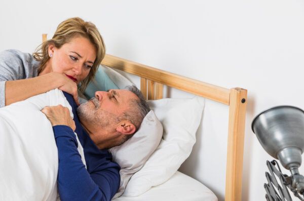 Coppia senior sdraiata a parlare di una differenza.