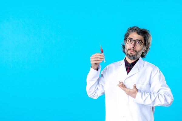 Medico maschio in camice bianco che tiene una siringa con contenuto biochimico.