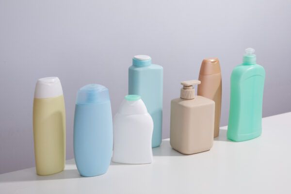 Diversi modelli e colori di bottiglie su una superficie strutturata e uno sfondo piatti.