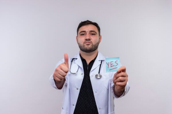 Giovane medico che raccomanda un trattamento e annuisce.
