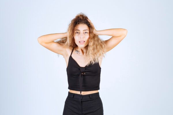 Ragazza con i capelli maltrattati che tiene la testa guardando la telecamera con un'espressione spaventata -Differenza tra: Caduta e diradamento.