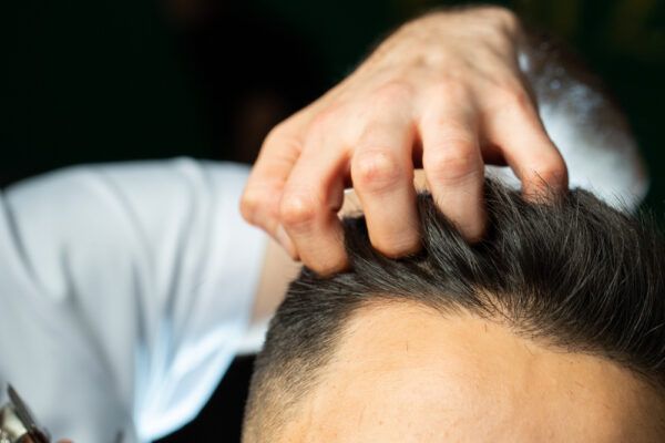 Ragazzo che riceve il massaggio del cuoio capelluto.